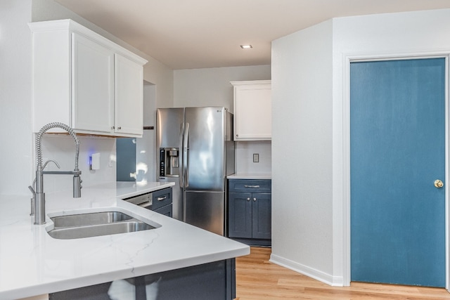 kitchen with stainless steel refrigerator with ice dispenser, white cabinetry, sink, and light hardwood / wood-style floors