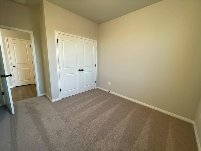 unfurnished bedroom featuring carpet and a closet