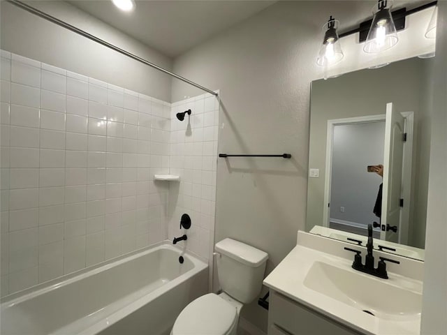 full bathroom featuring vanity, tiled shower / bath combo, and toilet