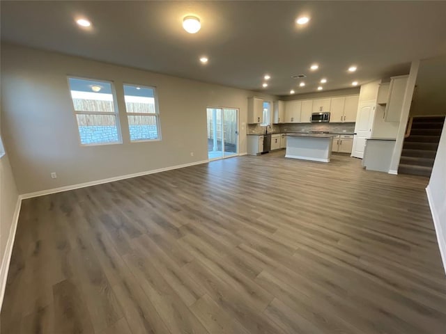 unfurnished living room with dark wood-type flooring