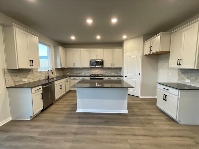 kitchen with a center island, stainless steel appliances, white cabinetry, and dark wood-type flooring