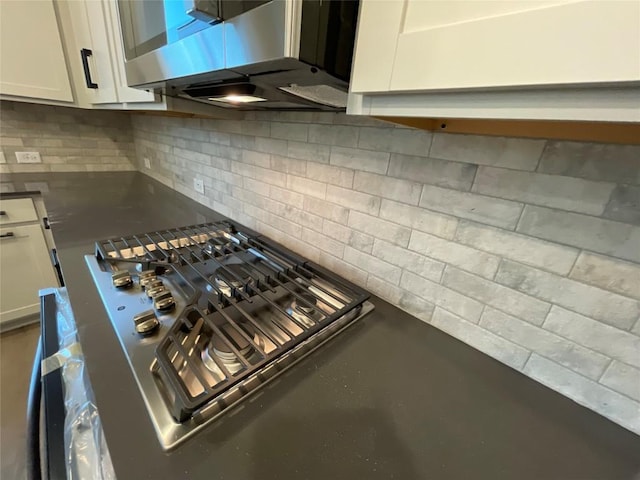 interior details featuring tasteful backsplash and white cabinets