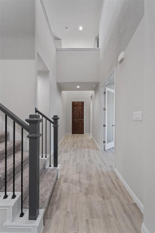 132 Scenic Hills Cir, Georgetown, TX 78628 - corridor with stairs, wood finished floors, baseboards, and a high ceiling