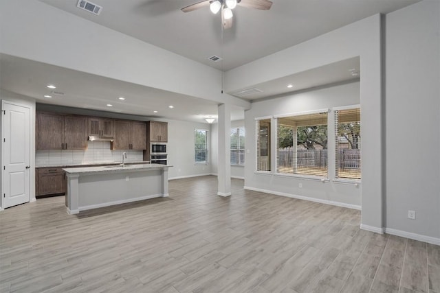 132 Scenic Hills Cir, Georgetown, TX 78628 - kitchen featuring open floor plan, a sink, appliances with stainless steel finishes, light countertops, and light wood finished floors