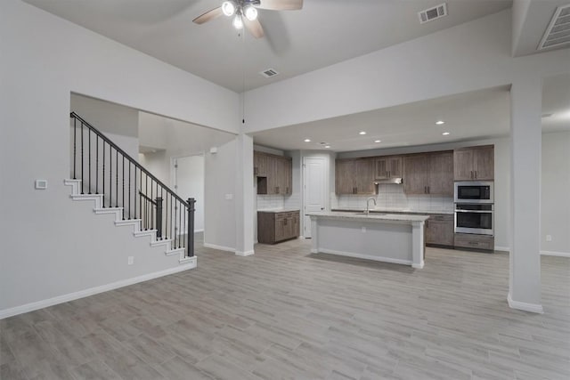 132 Scenic Hills Cir, Georgetown, TX 78628 - kitchen featuring stainless steel oven, built in microwave, open floor plan, a sink, and ceiling fan