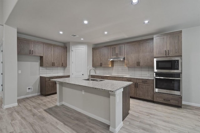 132 Scenic Hills Cir, Georgetown, TX 78628 - kitchen featuring stainless steel oven, built in microwave, a sink, black electric cooktop, and tasteful backsplash