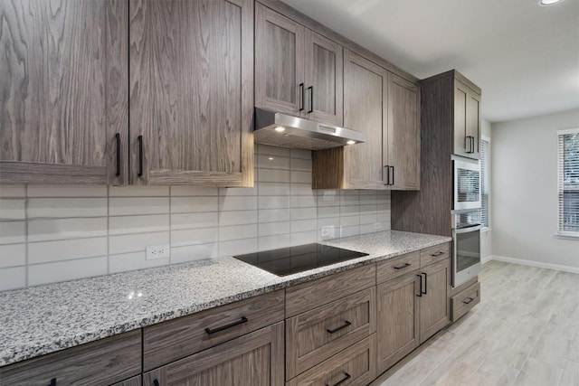132 Scenic Hills Cir, Georgetown, TX 78628 - kitchen featuring appliances with stainless steel finishes, under cabinet range hood, tasteful backsplash, and light stone countertops