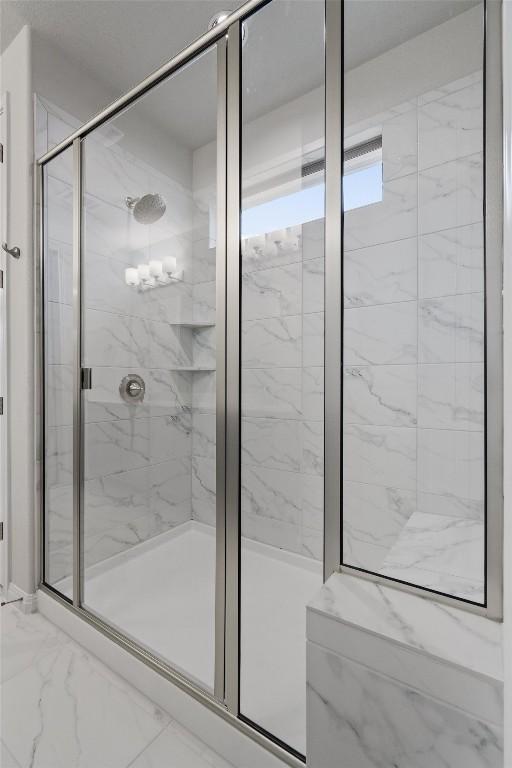 132 Scenic Hills Cir, Georgetown, TX 78628 - bathroom featuring a stall shower and marble look tile flooring