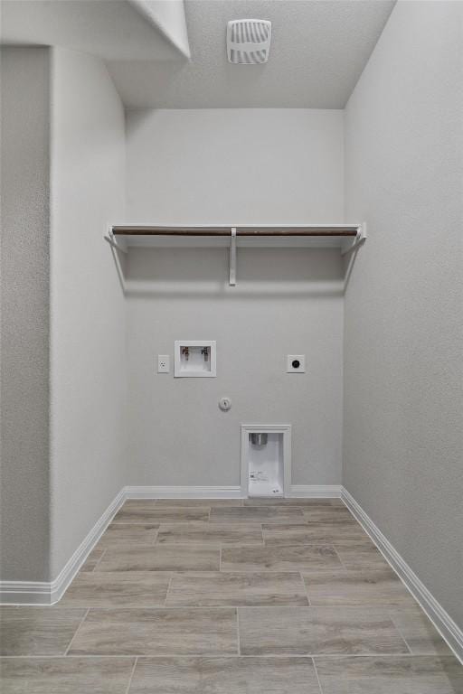 132 Scenic Hills Cir, Georgetown, TX 78628 - laundry area featuring electric dryer hookup, hookup for a gas dryer, washer hookup, baseboards, and light wood finished floors