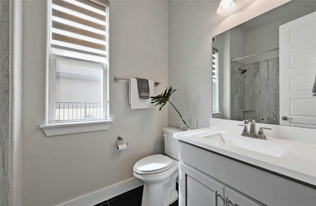 bathroom featuring toilet, vanity, tile patterned floors, and tiled shower