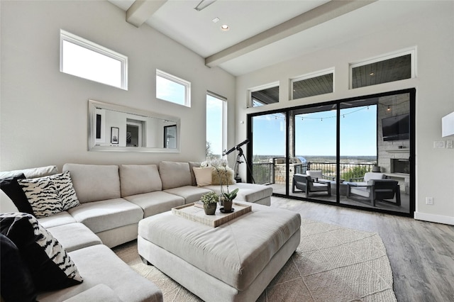 living room with a towering ceiling, hardwood / wood-style floors, and beam ceiling