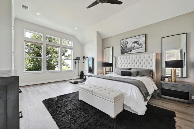 bedroom featuring ceiling fan, light wood-type flooring, and lofted ceiling