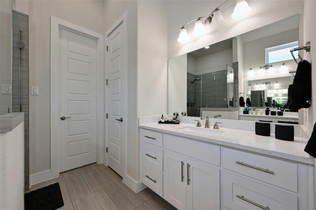 bathroom featuring tile patterned flooring, an enclosed shower, and vanity