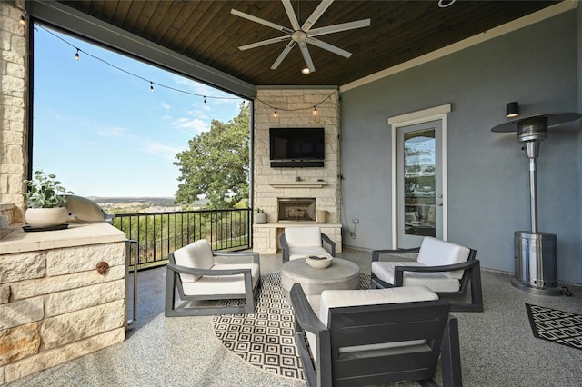 view of patio with ceiling fan and an outdoor living space with a fireplace