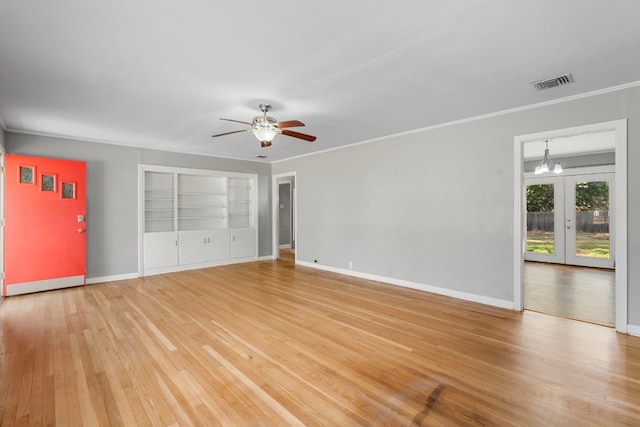 interior space featuring french doors, ceiling fan with notable chandelier, hardwood / wood-style flooring, and crown molding