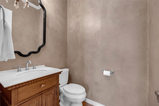 bathroom with vanity, toilet, and a notable chandelier