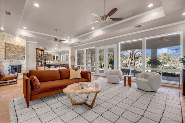 living room with a fireplace, ornamental molding, and a tray ceiling