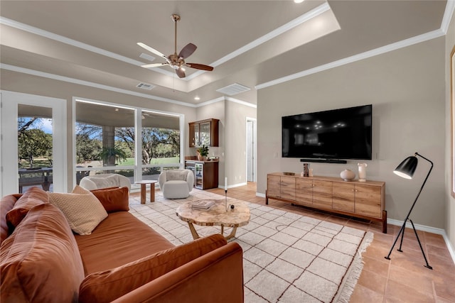 tiled living room with ceiling fan, a raised ceiling, and crown molding