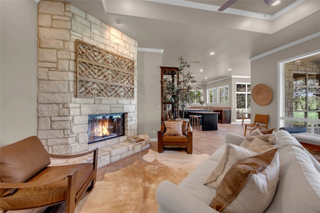 living room featuring a fireplace, light tile patterned flooring, and crown molding