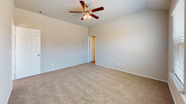 spare room featuring vaulted ceiling, light carpet, and ceiling fan