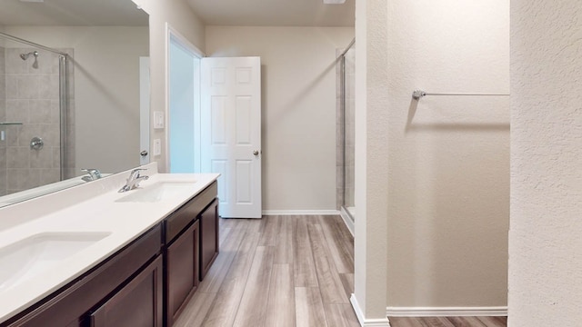 bathroom featuring walk in shower, vanity, and wood-type flooring