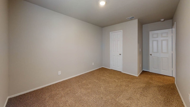 unfurnished bedroom featuring light colored carpet and a closet