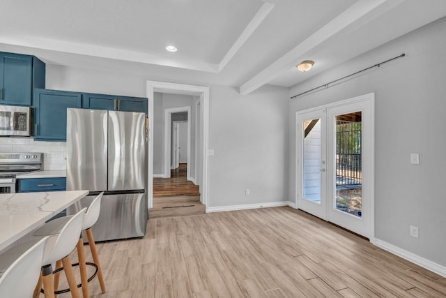 kitchen with blue cabinetry, french doors, tasteful backsplash, light wood-type flooring, and stainless steel appliances