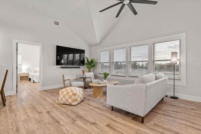 living room featuring high vaulted ceiling, light hardwood / wood-style flooring, and ceiling fan