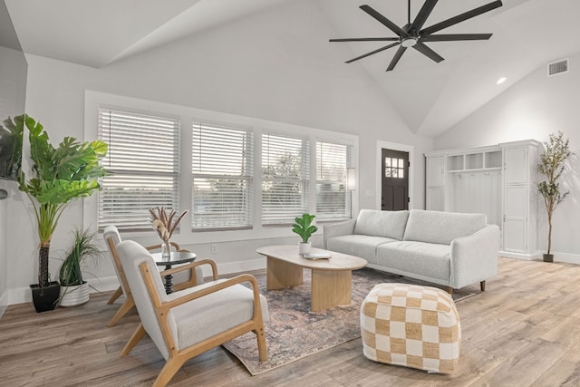 living room with light wood-type flooring, ceiling fan, and high vaulted ceiling