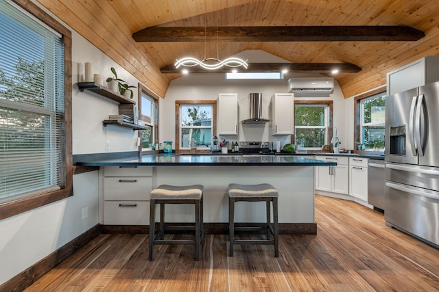 kitchen with vaulted ceiling with beams, white cabinetry, appliances with stainless steel finishes, wall chimney range hood, and wooden ceiling