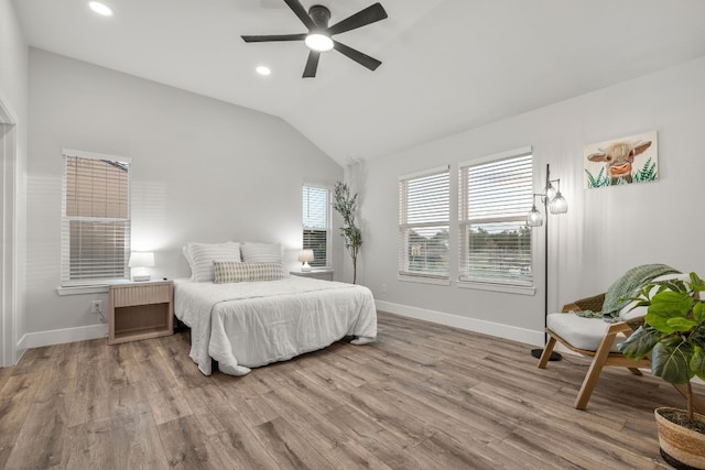 bedroom featuring light hardwood / wood-style floors, ceiling fan, and lofted ceiling