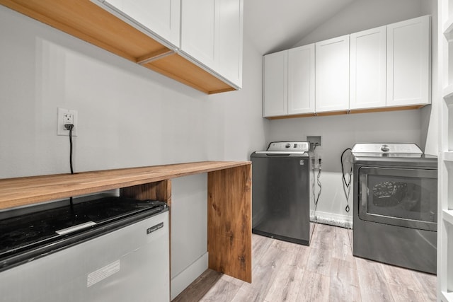 clothes washing area featuring light wood-type flooring, cabinets, and independent washer and dryer