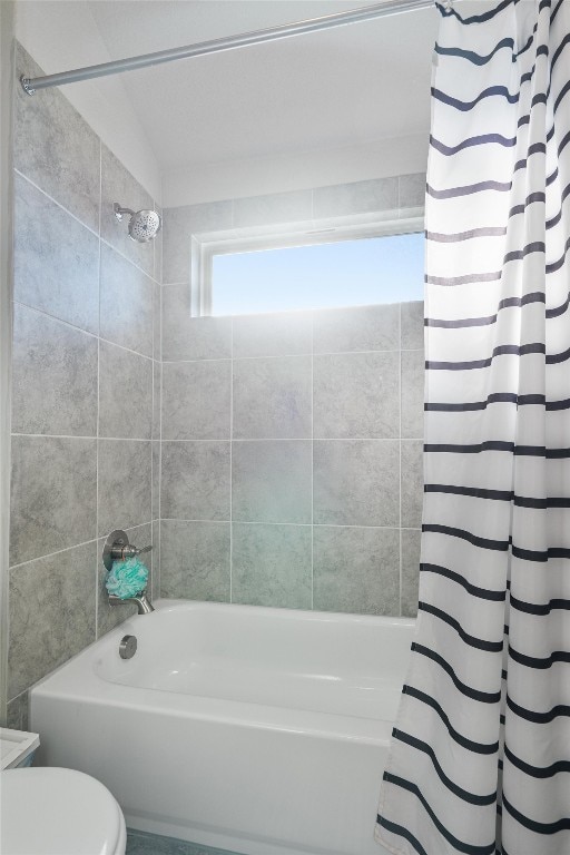 bathroom featuring shower / tub combo and toilet