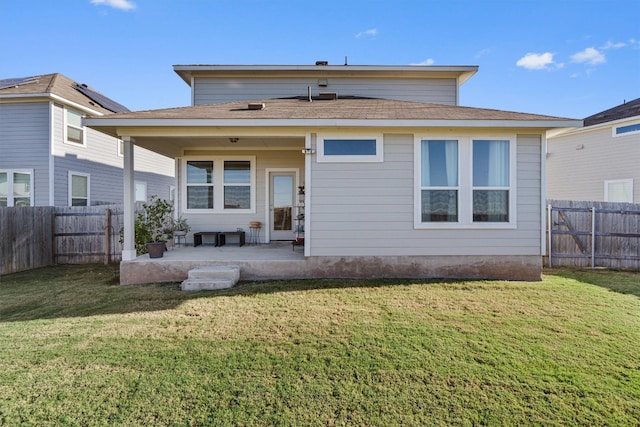 back of house featuring a lawn and a patio area