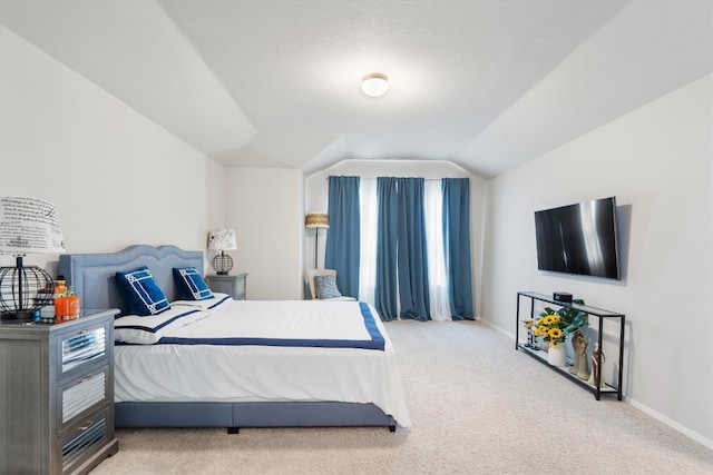 carpeted bedroom with a textured ceiling and lofted ceiling