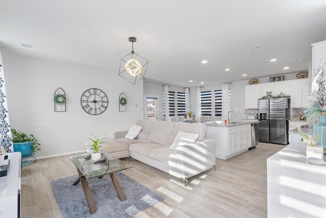 living room with sink and light hardwood / wood-style floors