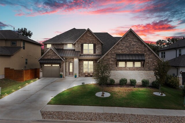 view of front of property featuring a garage and a lawn