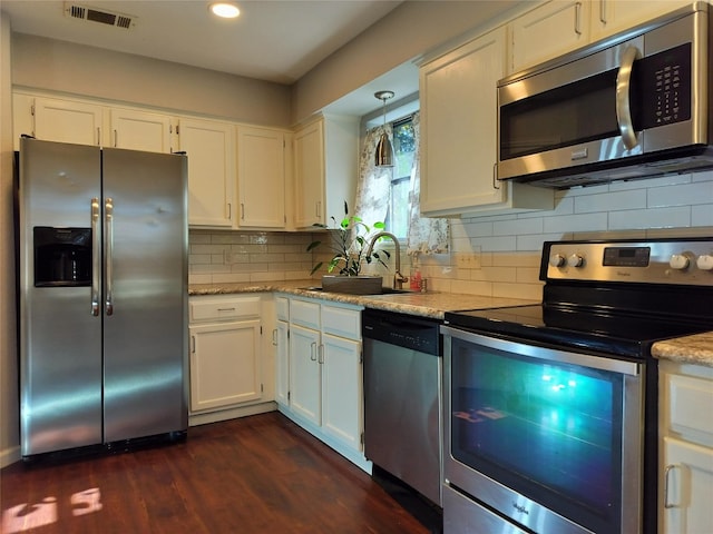 kitchen with white cabinetry, sink, pendant lighting, and appliances with stainless steel finishes