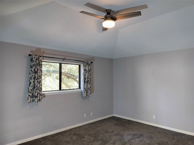 empty room with dark carpet, ceiling fan, and lofted ceiling