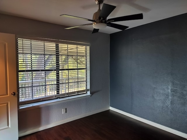 unfurnished room with ceiling fan and dark wood-type flooring