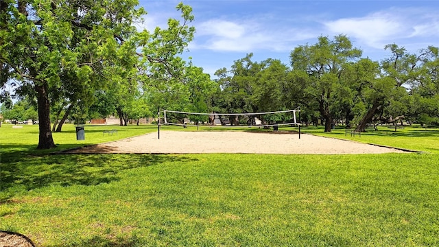 view of community with volleyball court and a lawn