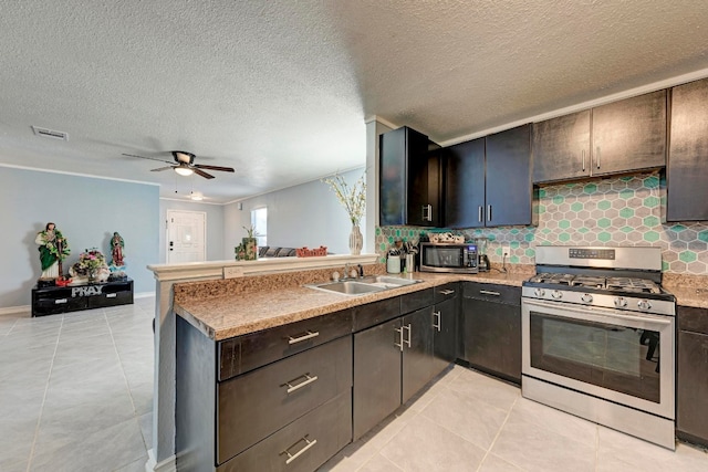 kitchen featuring appliances with stainless steel finishes, kitchen peninsula, ceiling fan, sink, and light tile patterned flooring