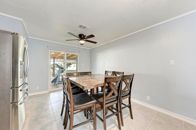 dining space featuring a textured ceiling, ceiling fan, ornamental molding, and light tile patterned floors