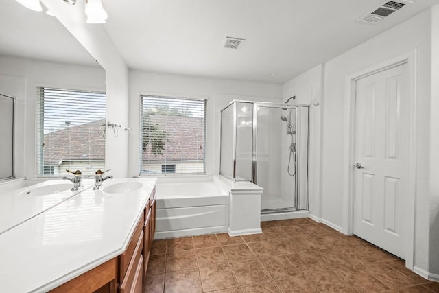 bathroom with tile patterned floors, vanity, and shower with separate bathtub