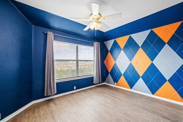 empty room with hardwood / wood-style flooring and ceiling fan