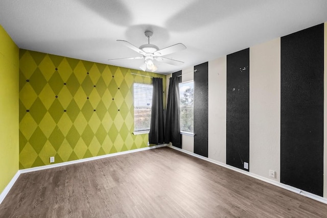 empty room with ceiling fan and hardwood / wood-style flooring