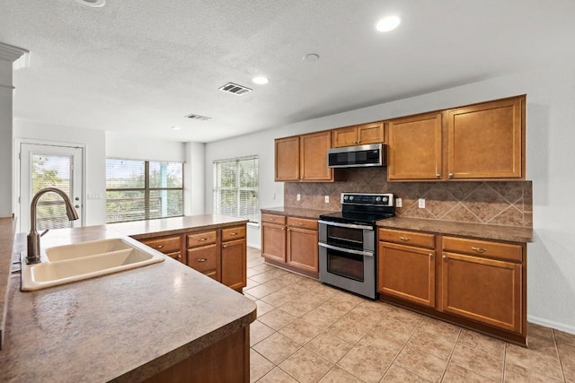 kitchen with an island with sink, stainless steel appliances, plenty of natural light, and sink