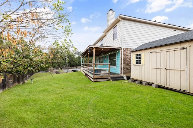 back of house with a yard, a storage unit, and a deck