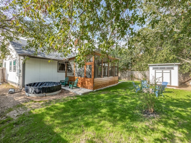 view of yard featuring a sunroom, a patio area, and a storage unit