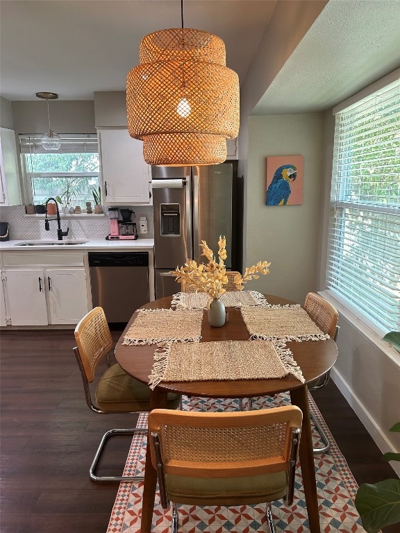 dining space with dark wood-type flooring, plenty of natural light, and sink